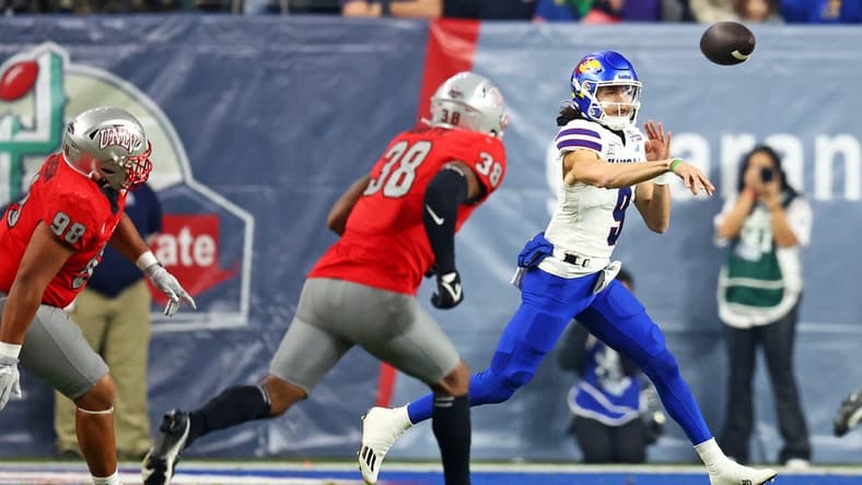 Dec 26, 2023; Phoenix, AZ, USA; Kansas Jayhawks quarterback Jason Bean (9) throws a pass against UNLV Rebels linebacker Marsel McDuffie (38) during the first quarter in the Guaranteed Rate Bowl at Chase Field. Mandatory Credit: Mark J. Rebilas-USA TODAY Sports