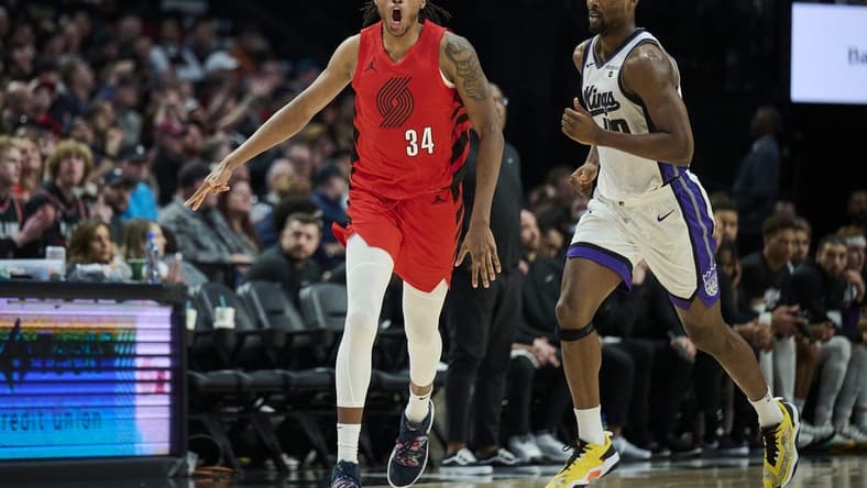 Dec 26, 2023; Portland, Oregon, USA; Portland Trail Blazers forward Jabari Walker (34) celebrates making a three point basket during the second half against Sacramento Kings forward Harrison Barnes (40) at Moda Center. Mandatory Credit: Troy Wayrynen-USA TODAY Sports