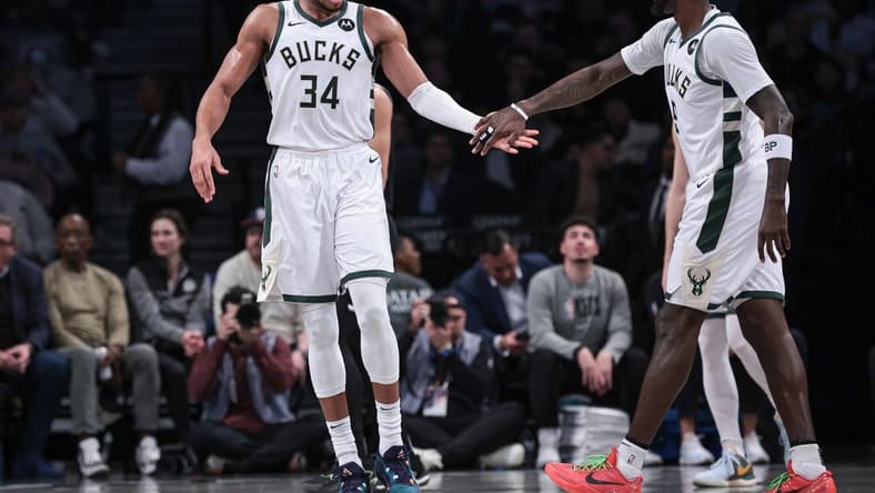 Dec 27, 2023; Brooklyn, New York, USA; Milwaukee Bucks forward Giannis Antetokounmpo (34) slaps hands with forward Bobby Portis (9) during the first half against the Brooklyn Nets at Barclays Center. Mandatory Credit: Vincent Carchietta-USA TODAY Sports