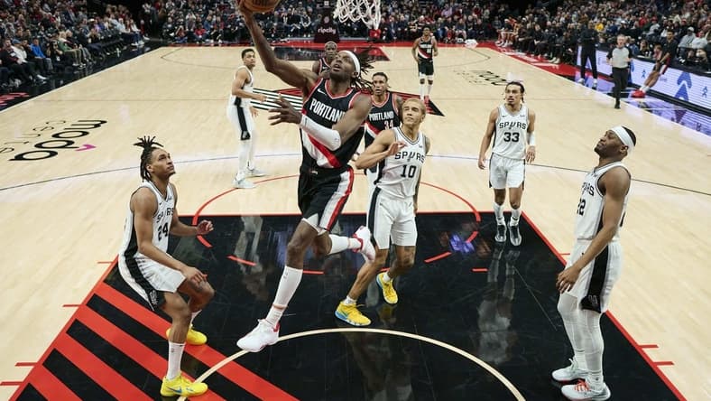 Dec 28, 2023; Portland, Oregon, USA; Portland Trail Blazers forward Jerami Grant (9) scores a basket during the second half against San Antonio Spurs forward Jeremy Sochan (10) at Moda Center. Mandatory Credit: Troy Wayrynen-USA TODAY Sports