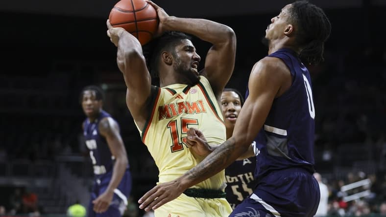 Dec 29, 2023; Coral Gables, Florida, USA; Miami Hurricanes forward Norchad Omier (15) protects the basketball from North Florida Ospreys guard Jasai Miles (0) during the first half at Watsco Center. Mandatory Credit: Sam Navarro-USA TODAY Sports