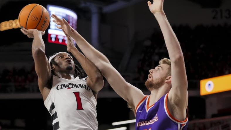 Dec 29, 2023; Cincinnati, Ohio, USA; Cincinnati Bearcats forward Kalu Ezikpe (1) drives to the basket against Evansville Aces forward Joshua Hughes (11) in the first half at Fifth Third Arena. Mandatory Credit: Aaron Doster-USA TODAY Sports