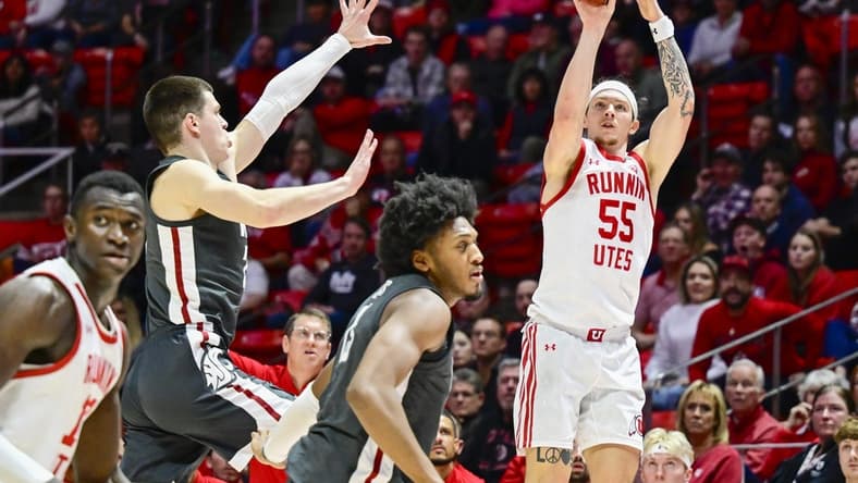 Dec 29, 2023; Salt Lake City, Utah, USA; Utah Utes guard Gabe Madsen (55) takes a three point shot over Washington State Cougars forward Andrej Jakimovski (23) during the second half at the Jon M. Huntsman Center. Mandatory Credit: Christopher Creveling-USA TODAY Sports