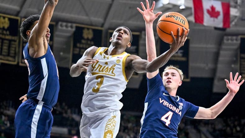 Dec 30, 2023; South Bend, Indiana, USA; Notre Dame Fighting Irish guard Markus Burton (3) shoots between Virginia Cavaliers guard Ryan Dunn (13) and guard Andrew Rohde (4) in the first half at the Purcell Pavilion. Mandatory Credit: Matt Cashore-USA TODAY Sports