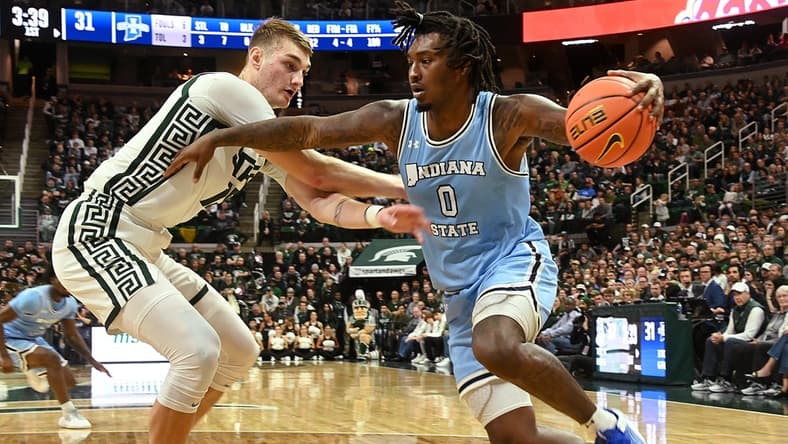 Dec 30, 2023; East Lansing, Michigan, USA; Indiana State Sycamores guard Xavier Bledson (0) drives against Michigan State Spartans center Carson Cooper (15) during the first half at Jack Breslin Student Events Center. Mandatory Credit: Dale Young-USA TODAY Sports