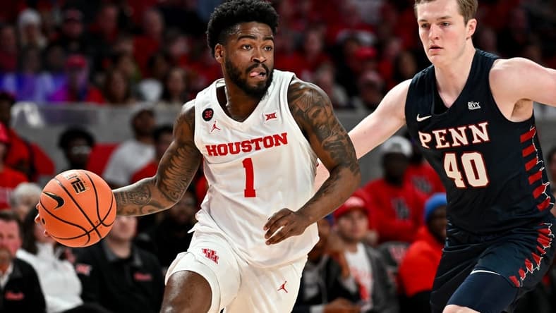 Dec 30, 2023; Houston, Texas, USA; Houston Cougars guard Jamal Shead (1) controls the ball as Pennsylvania Quakers guard George Smith (40) defends during the first half at Fertitta Center. Mandatory Credit: Maria Lysaker-USA TODAY Sports