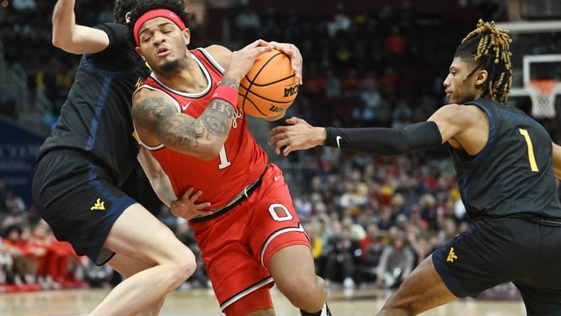 Dec 30, 2023; Cleveland, Ohio, USA; Ohio State Buckeyes guard Roddy Gayle Jr. (1) drives to the basket between West Virginia Mountaineers forward Ofri Naveh (9) and guard Noah Farrakhan (1) during the first half at Rocket Mortgage FieldHouse. Mandatory Credit: Ken Blaze-USA TODAY Sports