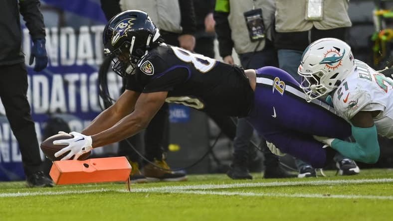 Dec 31, 2023; Baltimore, Maryland, USA;  Baltimore Ravens tight end Isaiah Likely (80) dives for a touchdown  as Miami Dolphins safety DeShon Elliott (21) defends during the first half at M&T Bank Stadium. Mandatory Credit: Tommy Gilligan-USA TODAY Sports
