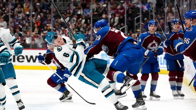 Dec 31, 2023; Denver, Colorado, USA; Colorado Avalanche center Nathan MacKinnon (29) hits San Jose Sharks defenseman Ty Emberson (6) in the second period at Ball Arena. Mandatory Credit: Ron Chenoy-USA TODAY Sports