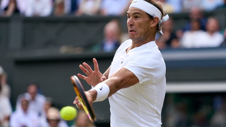 Jul 6, 2022; London, England, United Kingdom; Rafael Nadal (ESP) returns a shot during his quarter finals men s singles match against Taylor Fritz (USA) on Centre court at All England Lawn Tennis and Croquet Club. Mandatory Credit: Peter van den Berg-USA TODAY Sports