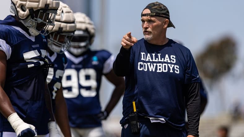 Aug 4, 2022; Oxnard, CA, USA; Dallas Cowboys defensive coordinator Dan Quinn talks to players during training camp at River Ridge Playing Fields in Oxnard, California. Mandatory Credit: Jason Parkhurst-USA TODAY Sports