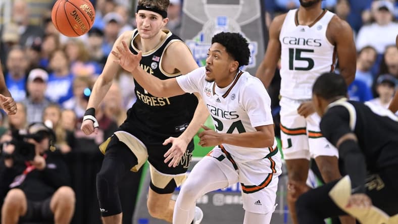Mar 9, 2023; Greensboro, NC, USA; Miami (Fl) Hurricanes guard Nijel Pack (24) with the ball as Wake Forest Demon Deacons forward Andrew Carr (11) defends during the second half of the quarterfinals of the ACC tournament at Greensboro Coliseum. Mandatory Credit: Bob Donnan-USA TODAY Sports