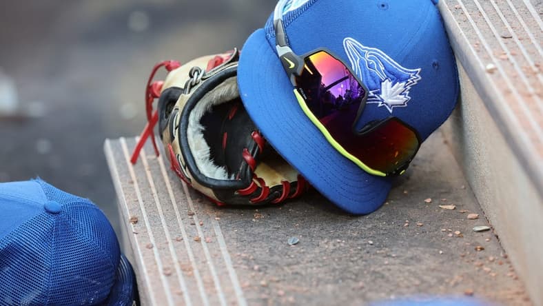 Mar 25, 2023; Dunedin, Florida, USA;  A detail view of Toronto Blue Jays hat and glove against the Detroit Tigers at TD Ballpark. Mandatory Credit: Kim Klement-USA TODAY Sports