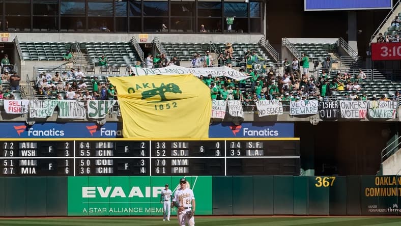 Sep 24, 2023; Oakland, California, USA; Fans in the outfield bleachers display homemade signs critical of the MLB Commissioner and Oakland Athletics ownership and Oakland Athletics infielder Zack Gelof (20) and outfielder Brent Rooker (25) stand on the field during the eighth inning against the Detroit Tigers at Oakland-Alameda County Coliseum. Mandatory Credit: Robert Edwards-USA TODAY Sports