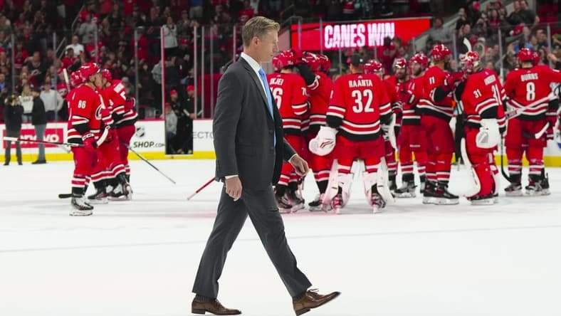 Oct 26, 2023; Raleigh, North Carolina, USA; Seattle Kraken head coach Dave Hakstol walks off the ice as the Carolina Hurricanes celebrate there victory win the over time at PNC Arena. Mandatory Credit: James Guillory-USA TODAY Sports