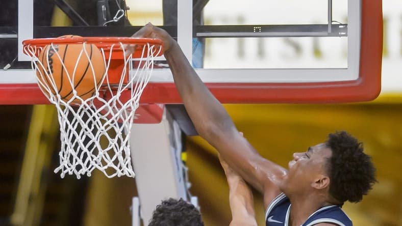 Utah State's Great Osobor, right, slam dunks over Bradley's Christian Davis in the second half of the Braves' home opener Saturday, Nov. 11, 2023 at Carver Arena.
