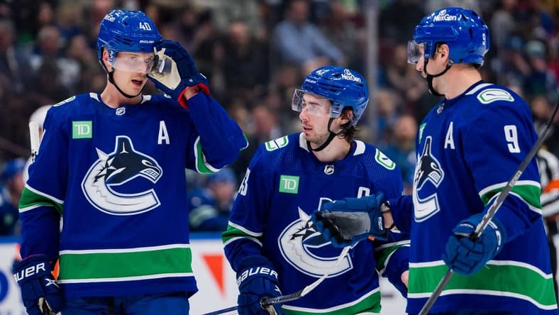 Nov 15, 2023; Vancouver, British Columbia, CAN; Vancouver Canucks forward Elias Pettersson (40) and defenseman Quinn Hughes (43) and forward J.T. Miller (9) discuss face off strategy against the New York Islanders in the third period at Rogers Arena. Vancouver won 4-3 in overtime. Mandatory Credit: Bob Frid-USA TODAY Sports