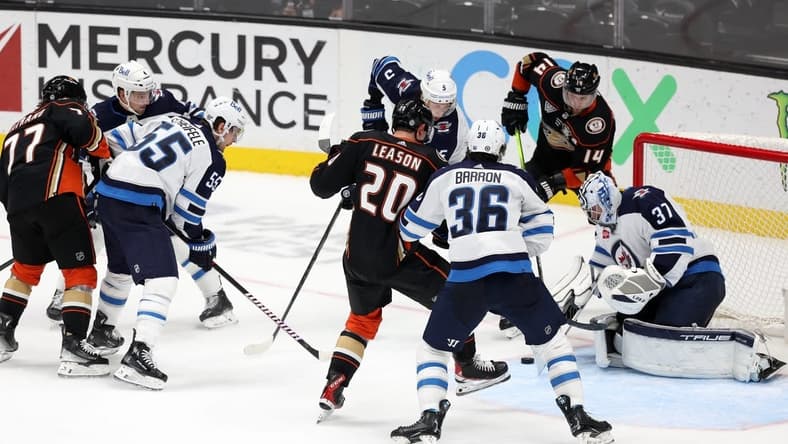 Dec 10, 2023; Anaheim, California, USA;  Winnipeg Jets goaltender Connor Hellebuyck (37) defends the goal against Anaheim Ducks right wing Brett Leason (20) during the third period at Honda Center. Mandatory Credit: Kiyoshi Mio-USA TODAY Sports