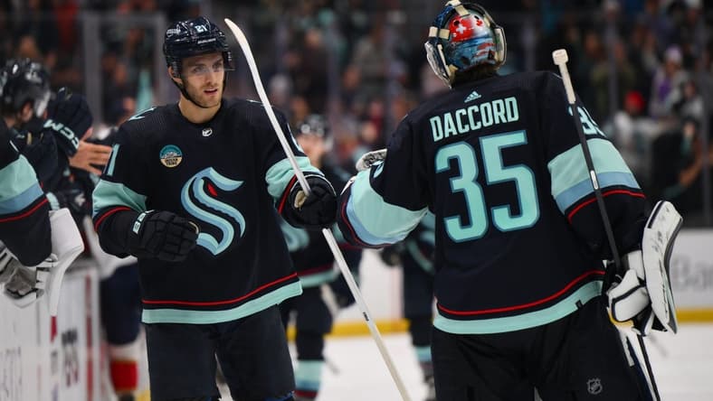 Dec 12, 2023; Seattle, Washington, USA; Seattle Kraken center Alex Wennberg (21) and goaltender Joey Daccord (35) celebrate after Wennberg scored a goal against the Florida Panthers during the third period at Climate Pledge Arena. Mandatory Credit: Steven Bisig-USA TODAY Sports