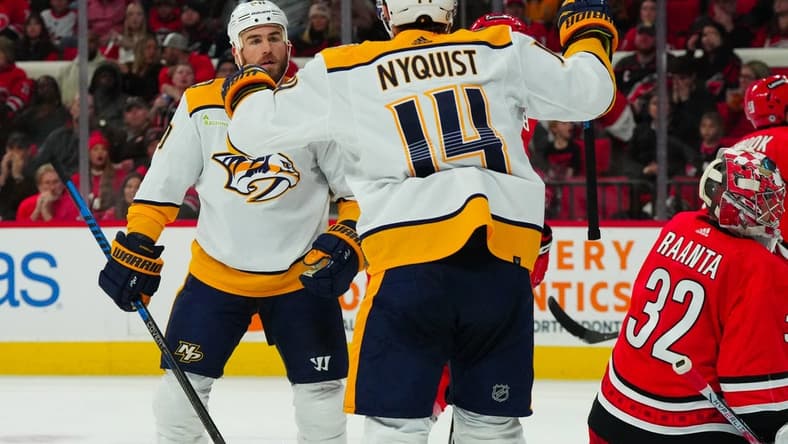 Dec 15, 2023; Raleigh, North Carolina, USA; Nashville Predators center Ryan O'Reilly (90) celebrates his gaol with center Gustav Nyquist (14) past Carolina Hurricanes goaltender Antti Raanta (32) during the second period at PNC Arena. Mandatory Credit: James Guillory-USA TODAY Sports