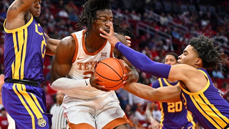 Dec 16, 2023; Houston, Texas, USA; Texas Longhorns forward Ze'Rik Onyema (21) battles for the ball against LSU Tigers guard Trae Hannibal (left) and guard Jalen Cook (right) during the first half at Toyota Center. Mandatory Credit: Maria Lysaker-USA TODAY Sports