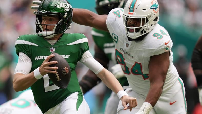 New York Jets quarterback Zach Wilson (2) tries to elude the pressure of Miami Dolphins defensive tackle Christian Wilkins (94) during the first half of an NFL game at Hard Rock Stadium in Miami Gardens, Dec. 17, 2023.