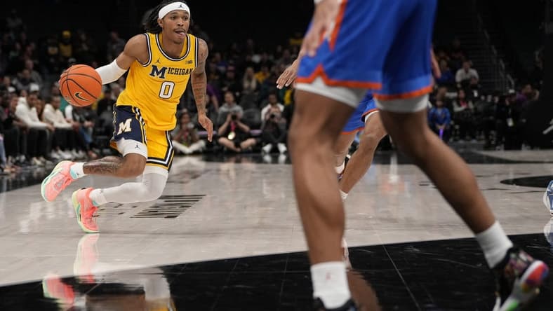 Dec 19, 2023; Charlotte, North Carolina, USA; Michigan Wolverines guard Dug McDaniel (0) drives to the basket against the Florida Gators during the first half at Spectrum Center. Mandatory Credit: Jim Dedmon-USA TODAY Sports