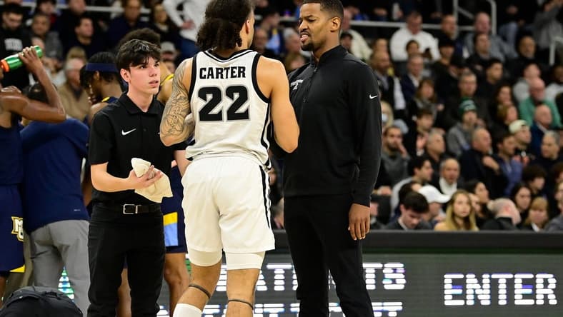 Dec 19, 2023; Providence, Rhode Island, USA; Providence Friars coach Kim English checks on an injured guard Devin Carter (22) during the first half against the Marquette Golden Eagles at Amica Mutual Pavilion. Mandatory Credit: Eric Canha-USA TODAY Sports