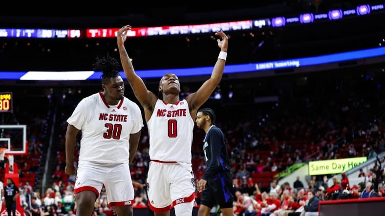 Dec 20, 2023; Raleigh, North Carolina, USA; North Carolina State Wolfpack guard DJ Horne (0) scores a three pointer and reacts with forward DJ Burns Jr. (30) during the second half against Saint Louis Billikens at PNC Arena. Mandatory Credit: Jaylynn Nash-USA TODAY Sports