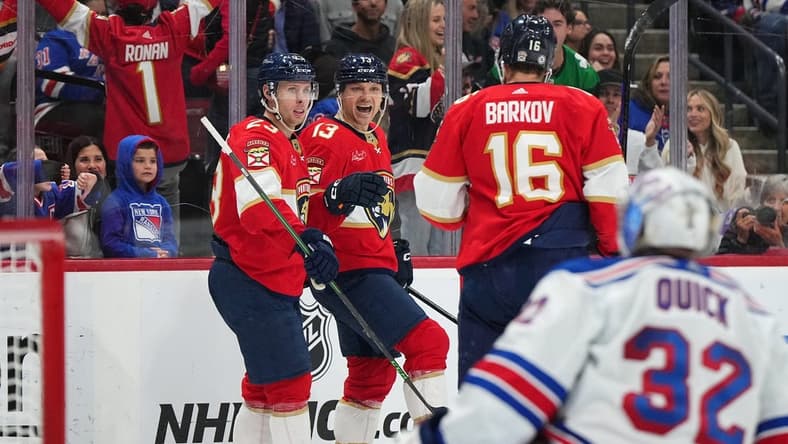 Dec 29, 2023; Sunrise, Florida, USA; Florida Panthers center Sam Reinhart (13) celebrates his goal on New York Rangers goaltender Jonathan Quick (32) with center Carter Verhaeghe (23) and center Aleksander Barkov (16) during the second period at Amerant Bank Arena. Mandatory Credit: Jasen Vinlove-USA TODAY Sports