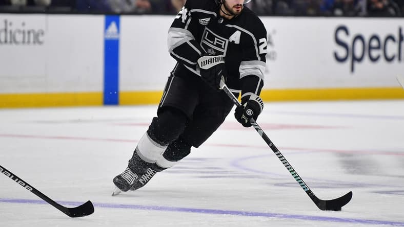Dec 30, 2023; Los Angeles, California, USA; Los Angeles Kings center Phillip Danault (24) moces the puck against the Edmonton Oilers during the second period at Crypto.com Arena. Mandatory Credit: Gary A. Vasquez-USA TODAY Sports