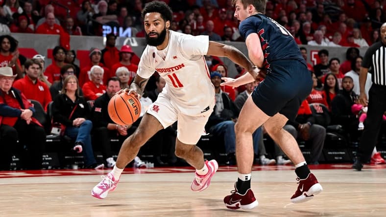 Dec 30, 2023; Houston, Texas, USA; Houston Cougars guard Damian Dunn (11) drives to the basket as Pennsylvania Quakers guard Sam Brown (11) defends during the first half at Fertitta Center. Mandatory Credit: Maria Lysaker-USA TODAY Sports