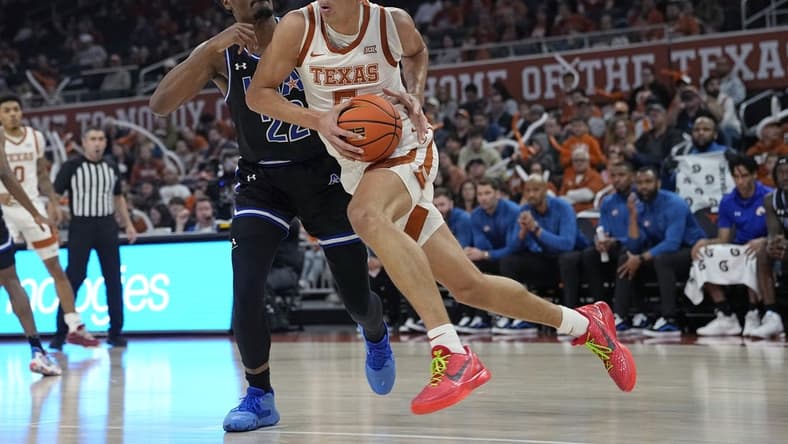 Jan 1, 2024; Austin, Texas, USA; Texas Longhorns forward Kadin Shedrick (5) drives to the basket while defended by Texas-Arlington Mavericks forward Shemar Wilson (22) during the first half at Moody Center. Mandatory Credit: Scott Wachter-USA TODAY Sports