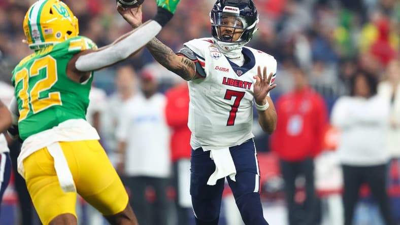 Jan 1, 2024; Glendale, AZ, USA; Liberty Flames quarterback Kaidon Salter (7) throws the ball under pressure from Oregon Ducks linebacker Emar'rion Winston (32) during the second half in the 2024 Fiesta Bowl at State Farm Stadium. Mandatory Credit: Mark J. Rebilas-USA TODAY Sports