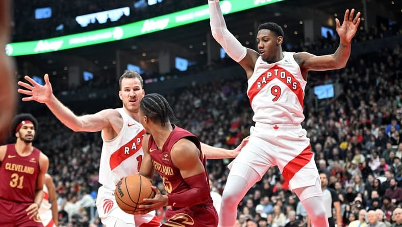 Jan 1, 2024; Toronto, Ontario, CAN; Toronto Raptors center Jakob Poeltl (19) and forward RJ Barrett (9) defend their basket as Cleveland Cavaliers guard Isaac Okoro (35) looks to make a pass in the first half at Scotiabank Arena. Mandatory Credit: Dan Hamilton-USA TODAY Sports
