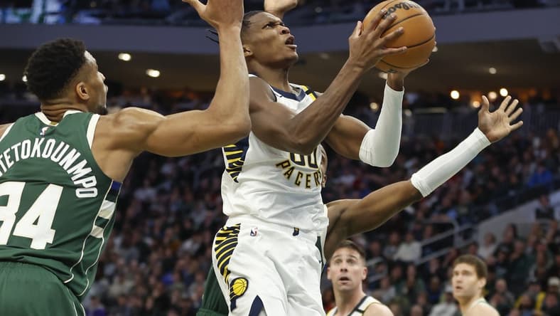 Jan 1, 2024; Milwaukee, Wisconsin, USA; Indiana Pacers guard Bennedict Mathurin (00) goes to the basket against Milwaukee Bucks forward Giannis Antetokounmpo (34) during the second half at Fiserv Forum. Mandatory Credit: Kamil Krzaczynski-USA TODAY Sports