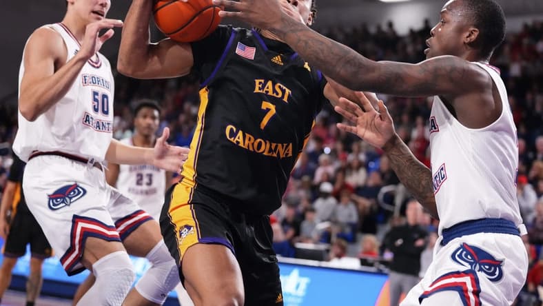 Jan 2, 2024; Boca Raton, Florida, USA; East Carolina Pirates guard Quentin Diboundje (7) dribbles against Florida Atlantic Owls guard Johnell Davis (1) during the first half at Eleanor R. Baldwin Arena. Mandatory Credit: Rich Storry-USA TODAY Sports