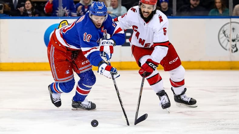 Jan 2, 2024; New York, New York, USA; New York Rangers left wing Artemi Panarin (10) and Carolina Hurricanes defenseman Jalen Chatfield (5) battle for the puck during the first period at Madison Square Garden. Mandatory Credit: Danny Wild-USA TODAY Sports