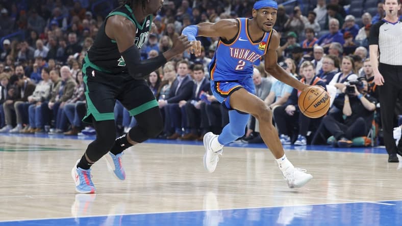 Jan 2, 2024; Oklahoma City, Oklahoma, USA; Oklahoma City Thunder guard Shai Gilgeous-Alexander (2) drives to the basket beside Boston Celtics guard Jrue Holiday (4) during the first quarter at Paycom Center. Mandatory Credit: Alonzo Adams-USA TODAY Sports
