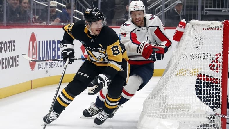 Jan 2, 2024; Pittsburgh, Pennsylvania, USA; Pittsburgh Penguins center Sidney Crosby (87) moves the puck behind the net as Washington Capitals defenseman Nick Jensen (3) chases during the first period at PPG Paints Arena. Mandatory Credit: Charles LeClaire-USA TODAY Sports
