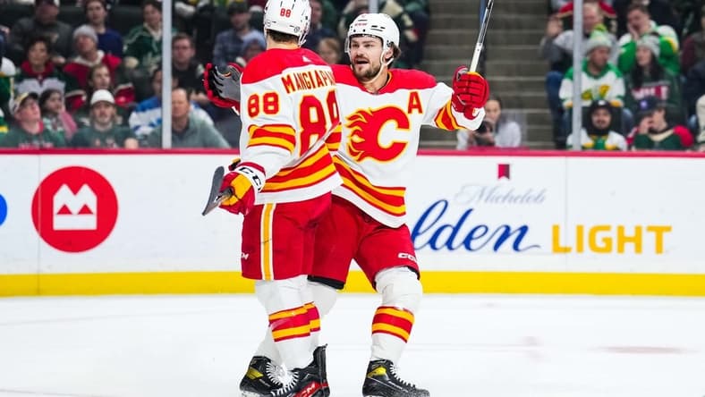 Jan 2, 2024; Saint Paul, Minnesota, USA; Calgary Flames left wing Andrew Mangiapane (88) celebrates his goal with Rasmus Andersson (4) during the first period against the Minnesota Wild at Xcel Energy Center. Mandatory Credit: Brace Hemmelgarn-USA TODAY Sports