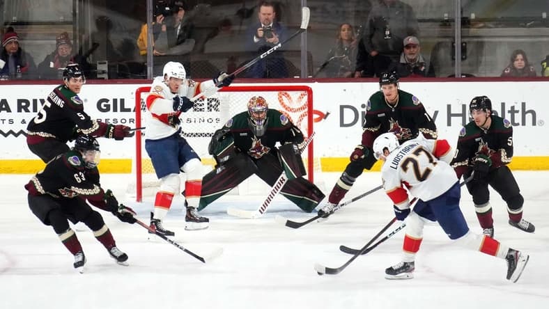 Jan 2, 2024; Tempe, Arizona, USA; Florida Panthers center Eetu Luostarinen (27) shoots against Arizona Coyotes goaltender Karel Vejmelka (70) during the second period at Mullett Arena. Mandatory Credit: Joe Camporeale-USA TODAY Sports