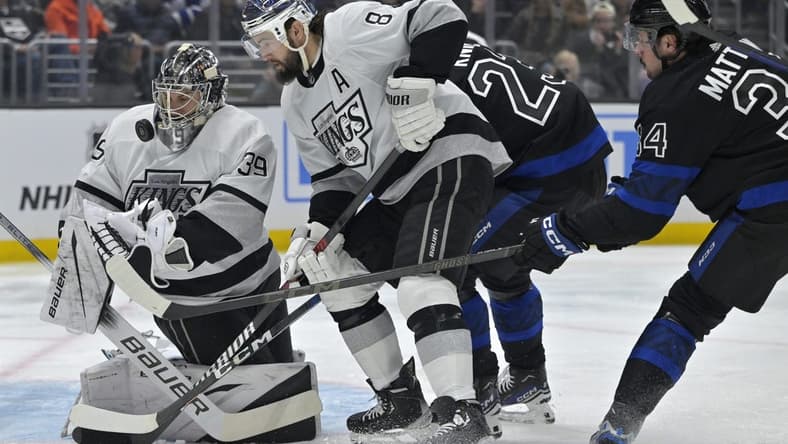 Jan 2, 2024; Los Angeles, California, USA; Los Angeles Kings goaltender Cam Talbot (39) makes a save off a shot by Toronto Maple Leafs left wing Matthew Knies (23) as Los Angeles Kings defenseman Drew Doughty (8) defends in the first period at Crypto.com Arena. Mandatory Credit: Jayne Kamin-Oncea-USA TODAY Sports