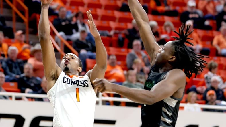 Oklahoma State's Bryce Thompson (1) goes up for a basket as Chicago State's Wesley Cardet Jr. (1) defends of the college basketball game between the Oklahoma State Cowboys and the Chicago State Cougars at Gallagher-Iba Arena in Stillwater, Okla., Wednesday, Jan. 3, 2024.