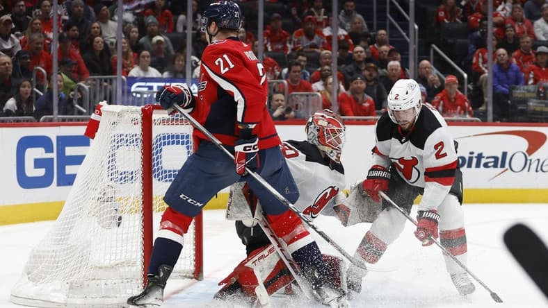 Jan 3, 2024; Washington, District of Columbia, USA; New Jersey Devils goaltender Nico Daws (50) makes a save in front of Washington Capitals center Aliaksei Protas (21) and Devils defenseman Brendan Smith (2) in the first period at Capital One Arena. Mandatory Credit: Geoff Burke-USA TODAY Sports