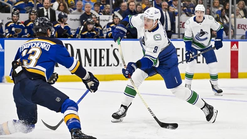 Jan 4, 2024; St. Louis, Missouri, USA; Vancouver Canucks defenseman Nikita Zadorov (91) shoots as St. Louis Blues right wing Alexey Toropchenko (13) defends during the first period at Enterprise Center. Mandatory Credit: Jeff Curry-USA TODAY Sports