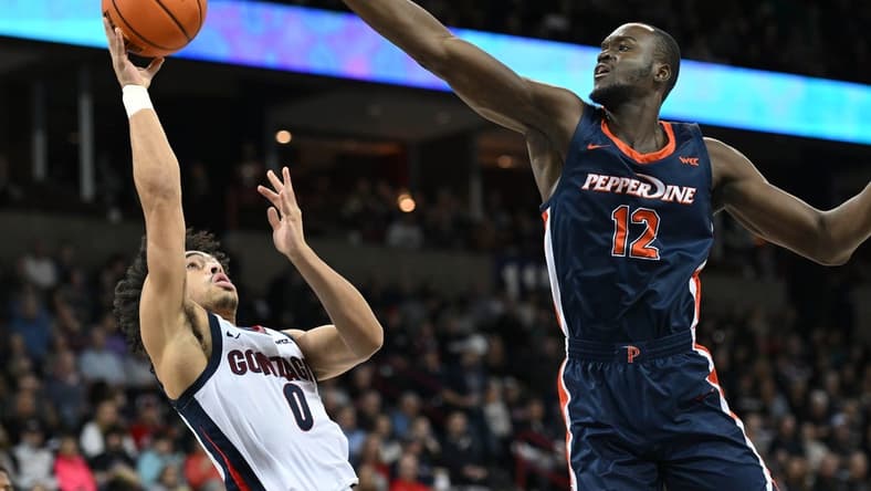 Jan 4, 2024; Spokane, Washington, USA; Gonzaga Bulldogs guard Ryan Nembhard (0) shoots the ball against Pepperdine Waves forward Boubacar Coulibaly (12) in the first half at Spokane Arena. Mandatory Credit: James Snook-USA TODAY Sports