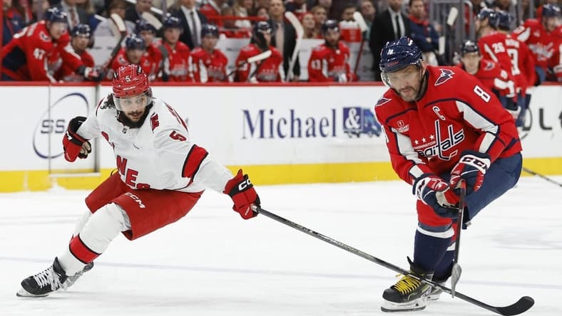 Jan 5, 2024; Washington, District of Columbia, USA; Washington Capitals left wing Alex Ovechkin (8) and Carolina Hurricanes defenseman Jalen Chatfield (5) battle for the puck d3p/ at Capital One Arena. Mandatory Credit: Geoff Burke-USA TODAY Sports