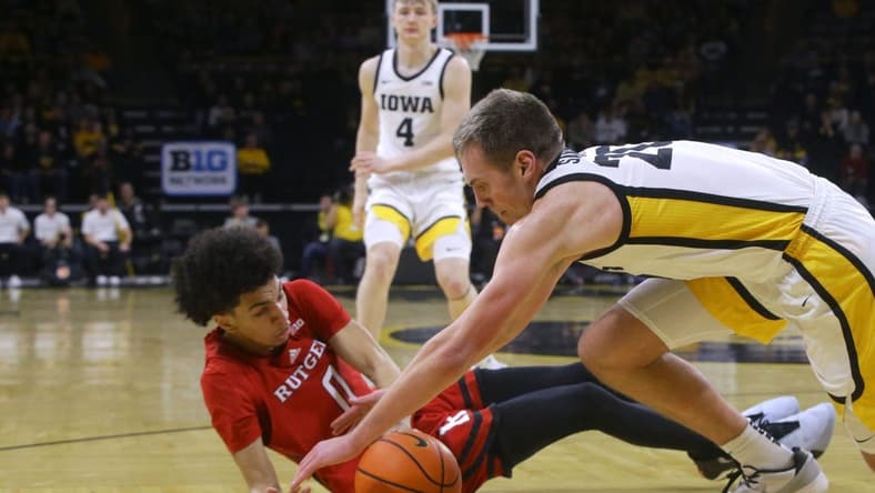 Iowa's Payton Sandfort (20) dives for a loose ball with Rutgers' Derek Simpson (0) Saturday, Jan. 6, 2024 at Carver-Hawkeye Arena in Iowa City, Iowa.