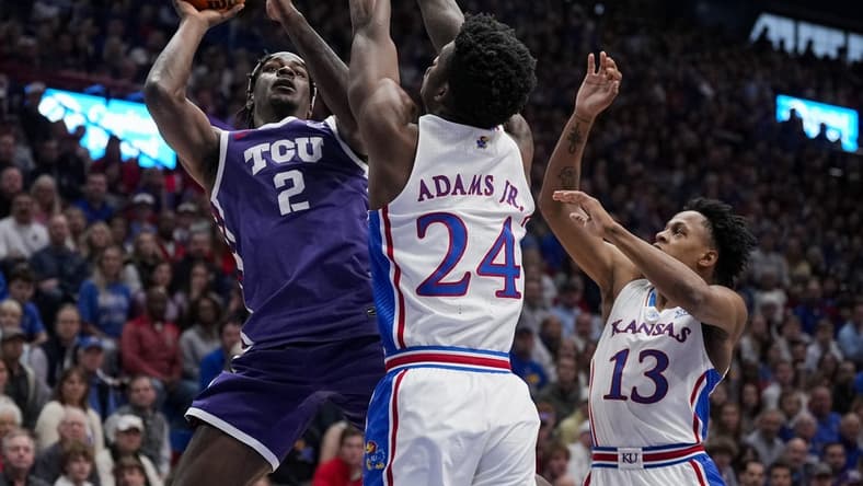 Jan 6, 2024; Lawrence, Kansas, USA; TCU Horned Frogs forward Emanuel Miller (2) shoots against Kansas Jayhawks forward K.J. Adams Jr. (24) and guard Elmarko Jackson (13) during the first half at Allen Fieldhouse. Mandatory Credit: Jay Biggerstaff-USA TODAY Sports